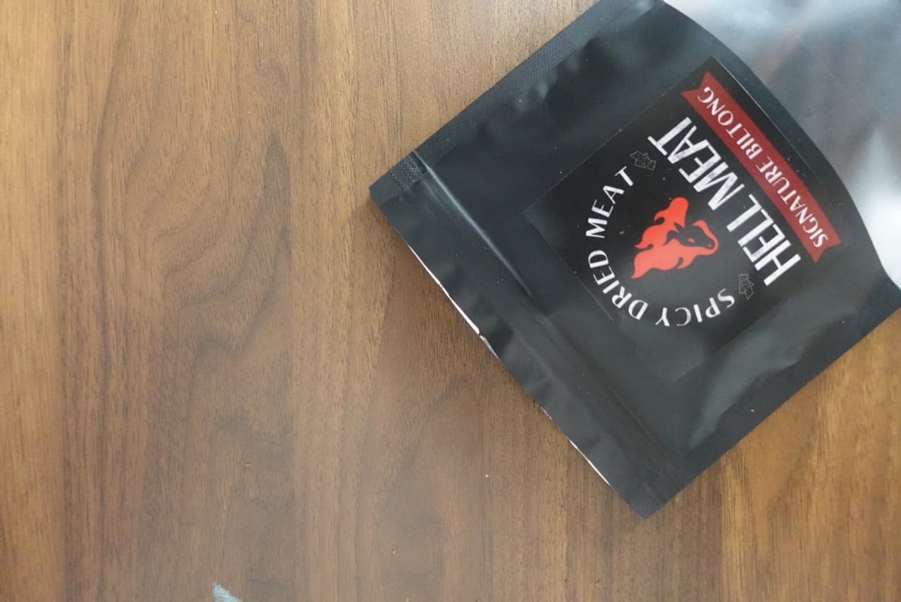 ซอง Hell Meat Signature Biltong วางบนโต๊ะไม้สีเข้ม